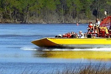 humans on a yellow airboat